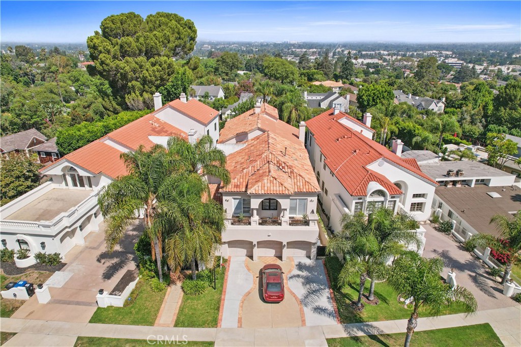 Discover Mediterranean luxury in this exquisite 5-bedroom, 4.5-bathroom home, offering 5,235 sqft of opulent living space. Entering through a grand double doors to a dramatic interior featuring soaring high ceilings, a dramatic spiral staircase, and breathtaking chandeliers, luxurious Italian curtains throughout. The elegant formal sitting, and dining room is perfect for hosting, while the modern kitchen invites culinary creativity. Upstairs the 1,100 sqft main suite boasts a fireplace, a sitting room, a ensuite bathroom, walk in closets and two balconies with serene patio and the pool view. 3 more large bedrooms upstairs and a private bedroom and full bath downstairs. Secluded backyard oasis features a tranquil pool and plenty of greenery. The property includes a 3-car garage and charger. In the neighborhood north of Mulholland Drive and south of Ventura Blvd.