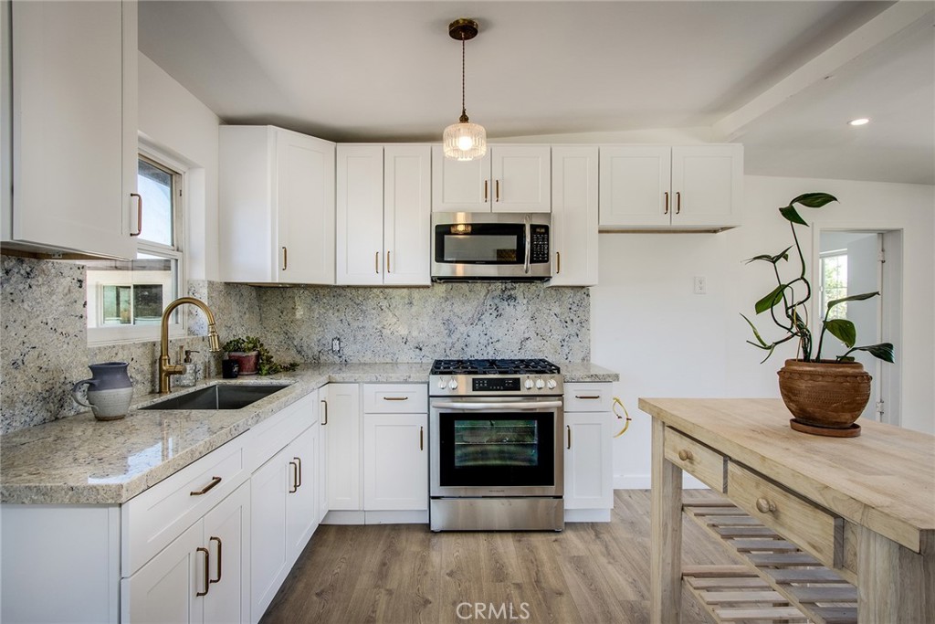 Welcome to this stunningly renovated home in the desirable Yucca Corral Acres, offering a perfect blend of modern amenities and serene desert living. Situated on a sprawling 1-acre lot, this turnkey property features a 1286 sq ft main house with 2 spacious bedrooms, den (perfect for a home office retreat or your own speakeasy), and fully updated bathroom. The 750 sq ft guest house – attached to the main house via the garage and with a private rear entrance - offers a spacious living area with 1 bedroom, den or possible 2nd bedroom, and full kitchen. This unit has also been fully renovated and can generate immediate rental income to offset your expenses or host friends and family. Both boast a brand new 30-year composition roof, new flooring throughout, and a newly renovated kitchens with updated appliances, stylish cabinets, fixtures, countertops, and backsplash. The living areas are bright and open, with large windows that let in plenty of natural light, providing a cozy and welcoming atmosphere. Fresh interior and exterior paint enhance the home’s aesthetic appeal, making it truly move-in ready. Additional features include an updated main electrical panel, a one-car garage, a 2-car carport, and a connected sewer for modern convenience.  At the rear of the property, an additional structure with bathroom lends itself to a future bunkhouse, caretaker quarters, yoga/art studio, home office, or otherwise. The expansive lot offers endless possibilities for creating your own desert oasis, with ample space for a garden, pool, or additional structures. Enjoy outdoor living with a spacious patio area, perfect for entertaining or relaxing under the stars. The property also includes a fenced-in area for animals with chicken coop already in place, and is zoned to allow for goats, chickens, and horses, to make your homestead dreams come true. Located in a highly sought-after neighborhood, this home is just minutes away from local shopping, dining, and entertainment in Yucca Valley, with easy access to Highway 62 for convenient trips to Joshua Tree National Park and the Coachella Valley. Hike by day via the trails at the rear of the property and unwind by night via nearby local hot spots The Tiny Pony, Copper Room, or Pappy and Harriets. Don’t miss this rare opportunity to own a beautifully updated home in a tranquil and picturesque setting, offering the best of Yucca Valley living.