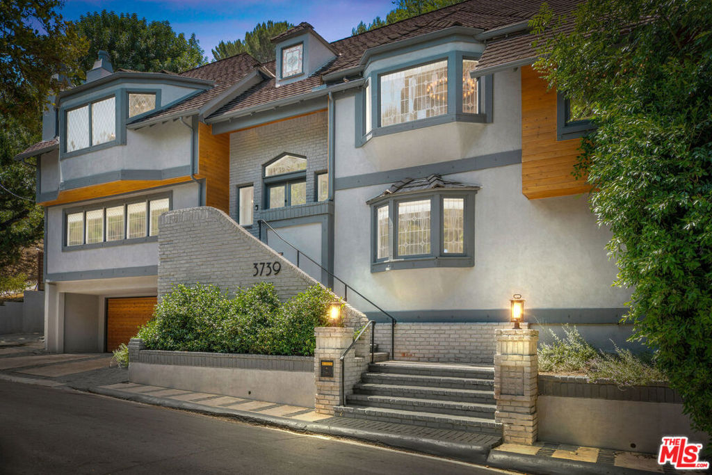 On a premiere street in the serenity of a Sherman Oaks canyon sits an architecturally stunning home whose interior was meticulously renovated in 2017 and whose exterior was remodeled in 2020. This 4 bedroom, 5 bathroom home boasts 3,872 square feet with custom build-ins throughout, and includes an additional office.  There are multiple living room areas flooded with light and enhanced by wood beams, spectacular leaded glass windows, vaulted ceilings, European white oak floors and two fireplaces.  The chef's kitchen is equipped with stainless steel appliances, stone countertops, custom cabinets, and an eat-in breakfast nook overlooking a multi-level deck.  Continue through french doors outside to experience the epitome of LA living with tree top views and ample space to entertain, dine outdoors, garden, or play.  The oversized primary retreat features another fireplace, a custom walk-in closet, a soaking tub, and steam shower.  With an elevator to take you from the garage to the interior floors, a vintage wine cellar and a private entry suite perfect for visiting family or in-laws, this home is not to be missed!  Located moments to the best Ventura Blvd. has to offer and within coveted Dixie Canyon Community Charter Elementary.
