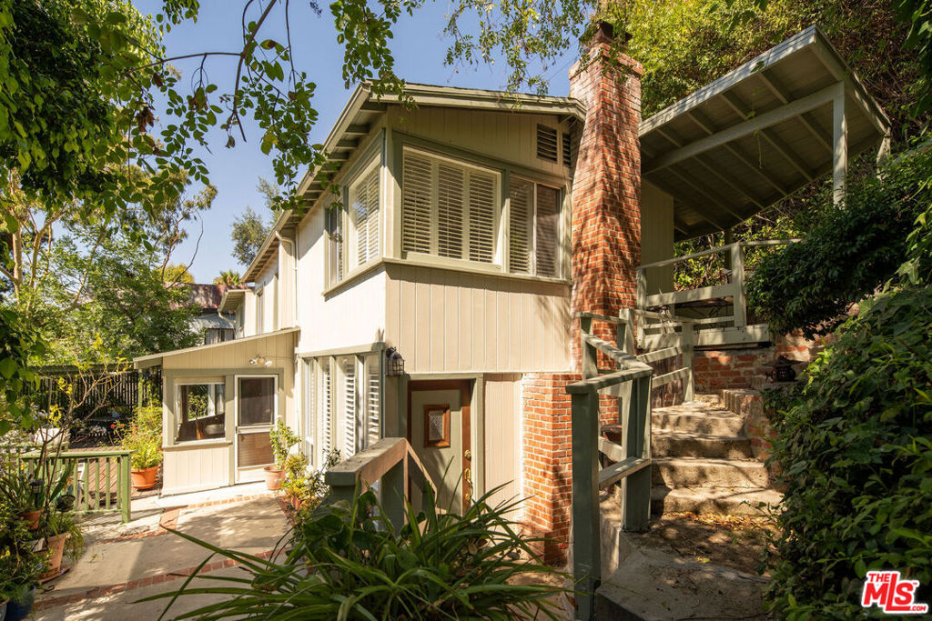 60+ years ago a young married couple chose Laurel Canyon to buy their first home.  The surrounding nature, canyon vibe and breathtaking views could not be duplicated.  Two children and many years later a lifetime of memories has been made.  Now it is time to pass this home to a new generation.  The drive up is a single lane that takes you to a magical enclave of homes unchanged from the Laurel Canyon of yesterday.  Not visible from the street - an unassuming gate leads you down a pathway of stairs to this magical 2-story abode.  North-facing views are explosive, yet privacy abounds.  The property consists of two separate lots (APN's) and totals more than 8800 sq feet of land.  On the first floor is a spacious living room w/decorative fireplace and a wood-paneled dining room.  Rows of windows in both rooms capture views & natural sunlight.  A cozy and functional yellow kitchen brings joy to the space.  A laundry area and storage complete the first floor.  On the second floor you will find many purposeful spaces.  A large primary suite with corner windows to the garden.  Two additional bedrooms, one full bath, a den / study area and a private office.  All with views of the gorgeous Laurel Canyon hills.  Of the outdoor deck - the owner said this (in her own words):  The spacious deck that we built became a favorite gathering place for just about everyone with impromptu parties for friends, large family gatherings, or just a space to experience alone for quiet contemplation, greeting the morning light or whispering good night as daylight fades and the trees and hillside across the way become silhouettes.  Reading these words one can truly feel what it is like to call this home.  Over the years, the owners have stabilized the hillside, added terracing and retaining walls.  Rebuilt and reinforced the deck.  Replaced the roof (approx 6 years ago), updated the electrical panel to 100 amps and updated the plumbing to copper.  The house was recently painted inside and out, many windows are double-paned and many other improvements have been done to maintain the home and property.  There is no garage, but there are designated parking spaces in front of the house.  A creative and tranquil retreat in legendary Laurel Canyon and just up the road from the famous Canyon Country Store.  Minutes to the Sunset Strip and the San Fernando Valley. The property is within the desirable Wonderland elementary school district (buyer to verify enrollment). Come experience the magic!  Private Showings only!