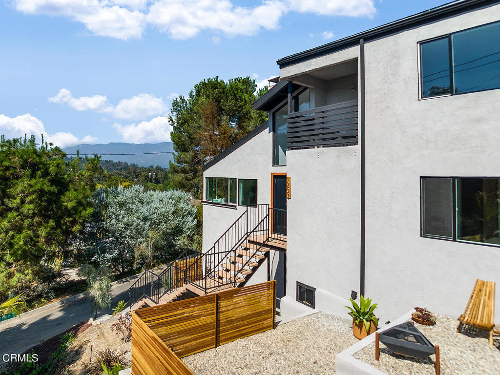 Modern, organic with treehouse views this San Rafael Hills home offers architecture and lifestyle in a premium Pasadena locale.  Set high above the street to maximize privacy and views, with original pebbletec aggregate floating steps artfully positioned against the terraced front yard, this home's exterior geometry suggests unique volumes inside.  A double height entry with soaring trapezoid windows opens to vaulted ceilings, bands of windows and stunning vistas of the San Gabriel Mountains. Natural light is plentiful and softly reflects off of wide plank white oak floors, imparting a sense of space and quiet airiness. A generous living room flows into the dining room with a picture window that frames multiple shades of green and a mountain backdrop.  The large renovated kitchen is bathed in light with quartz countertops, sleek white cabinetry and stainless steel sink plus appliances including a sleek Samsung smart fridge and enviable Fisher & Paykel double drawer dishwasher.  Conveniently located off the kitchen are a perfectly-sized family room and wide sliding door to the large outdoor patio -- the layout here allows easy entertaining, or everyday living and dining with SoCal style.  Three bedrooms enjoy updated and upgraded en-suite baths, each with bragging rights: rain shower heads, generous vanities and sleek fixtures.   An extra large garage offers direct access to the home, as well as a separate bonus space to use as a studio, gym, or tucked-away storage.  Finally, don't miss the outdoor living room/viewing deck at the top of the backyard - it's a spot to enjoy morning, noon and night.  With lifestyle, privacy and a coveted location off of lovely Laguna Road and the South Arroyo, and proximity to restaurants, shopping, and fun in Pasadena and Highland Park, plus easy freeway access, this home is a winner.