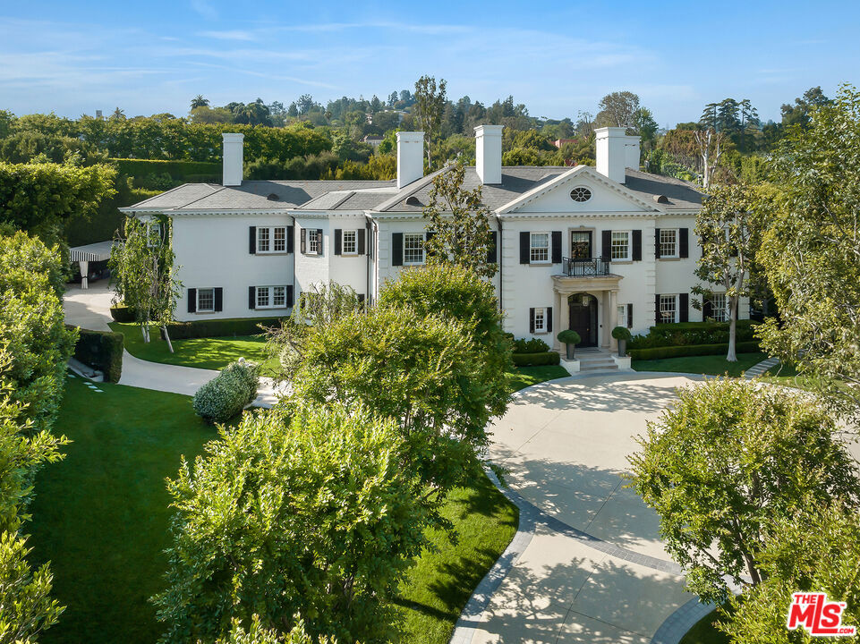 Set in the prestigious Lower Bel Air neighborhood, this spectacular traditional estate, designed by the renowned architect Richard Manion, offers complete privacy and seclusion. Recently updated with refined modern amenities, this gracious and stately residence epitomizes elegance, boasting state-of-the-art features and expansive grounds tailored for today's lifestyle. The dramatic two-story entry foyer, with its sweeping elegant staircase, leads to an inviting living room that seamlessly transitions into a full theater. The home also boasts a spacious library/office, complete with a bar, fireplace lounge, and a private outdoor patio with barrel sauna and separate entry. The beautiful formal dining room, accompanied by a convenient butler's pantry, provides an exquisite setting for memorable gatherings, while the gourmet chef's kitchen, equipped with a center island and commercial-grade appliances, opens to a large family room. This space offers a panoramic view of the meticulously landscaped grounds, including formal gardens, a sparkling pool, a spa, and enchanting fountains. The luxurious primary suite is a haven of tranquility, featuring dual, lavishly appointed bathrooms and closets, as well as a private patio overlooking the stunning grounds. Separate from the primary suite, there are three additional bedroom suites upstairs, ensuring privacy and comfort for family or guests. The estate also includes a large professional fitness studio and a separate Pilates studio with a bath. A dedicated security room, with fully upgraded systems, enhances the home's safety and peace of mind. Other notable features of this exceptional property include a large front motor court with gated and private driveway, expansive lawns, and formal gardens. Rarely does an estate of this quality and magnitude become available for purchase. Offering an unparalleled blend of classic elegance and modern luxury, in prime Lower Bel Air, with easy access to Beverly Hills and the Westside's shopping, dining and nightlife.